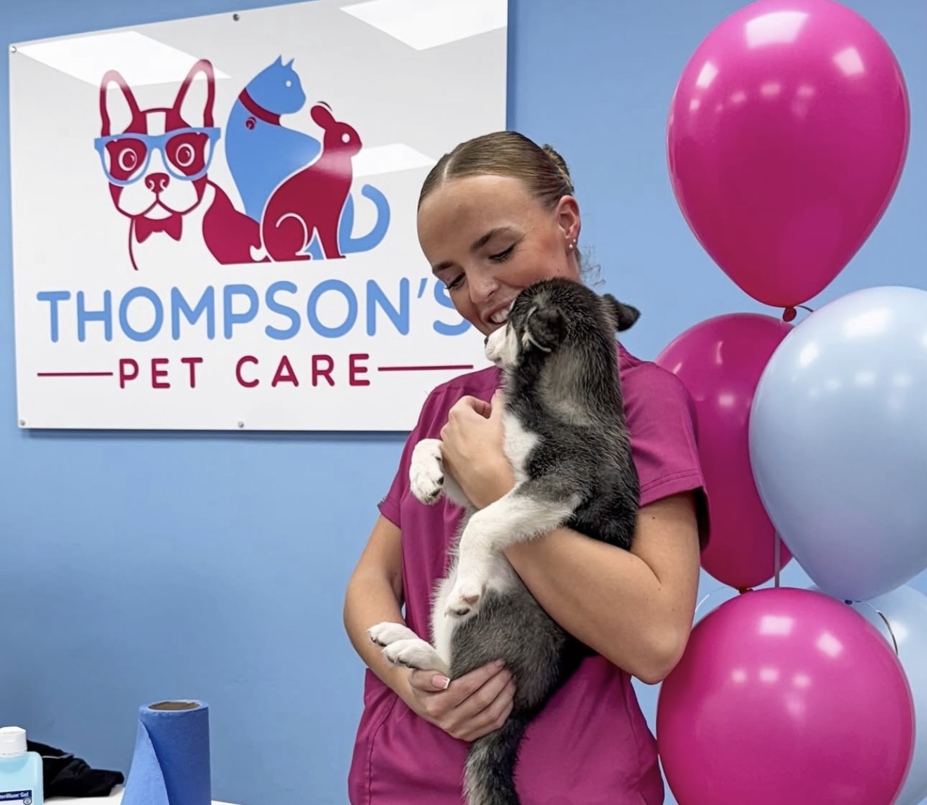 A member of our practice team gently holding a puppy